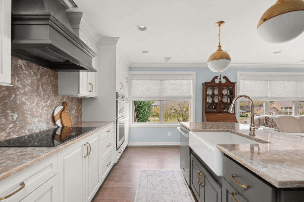 kitchen cambria quartz counters and backsplash stove top gray hood island apron sink brass pendants